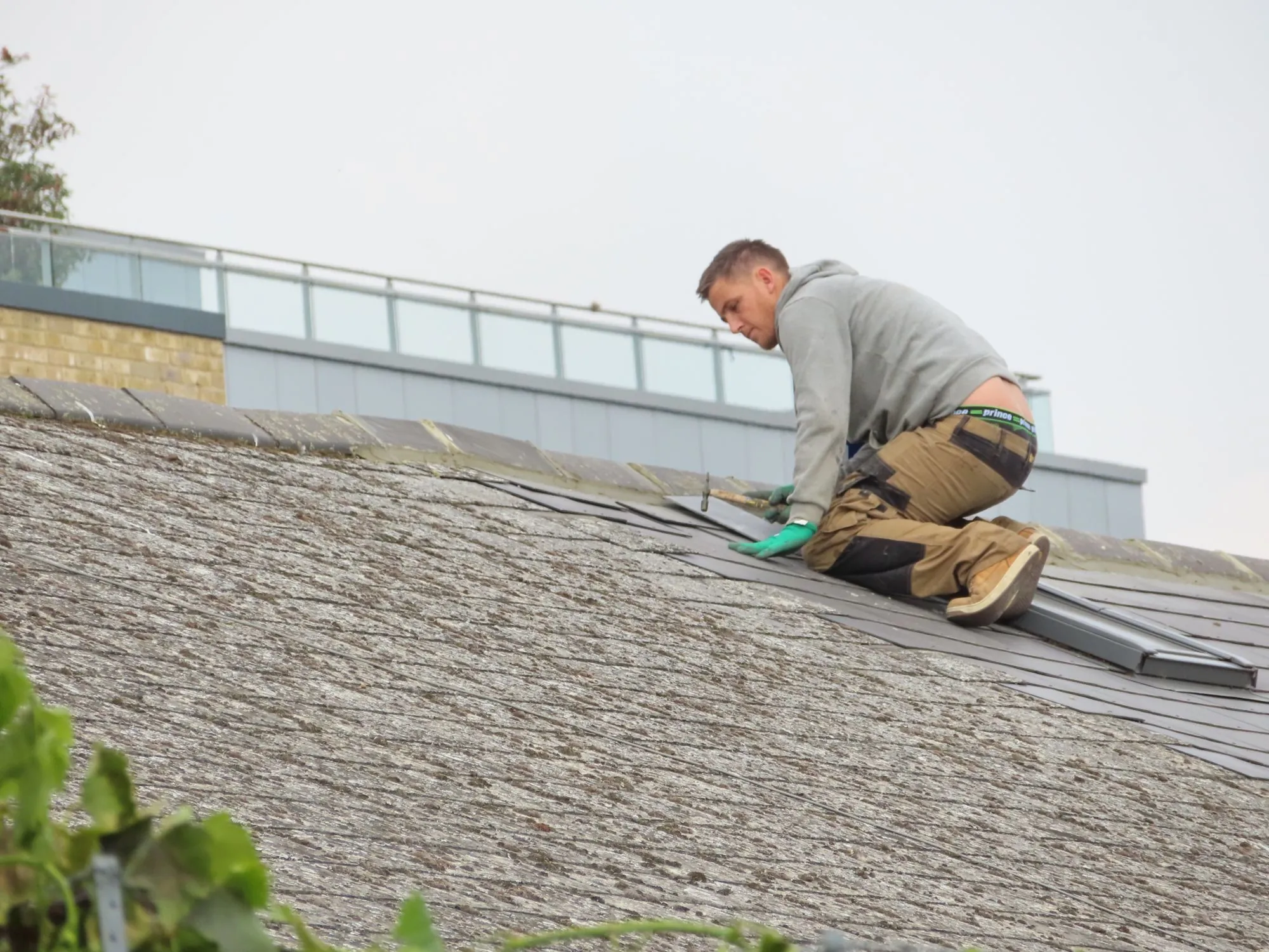 Roofer installing new shingles on a house