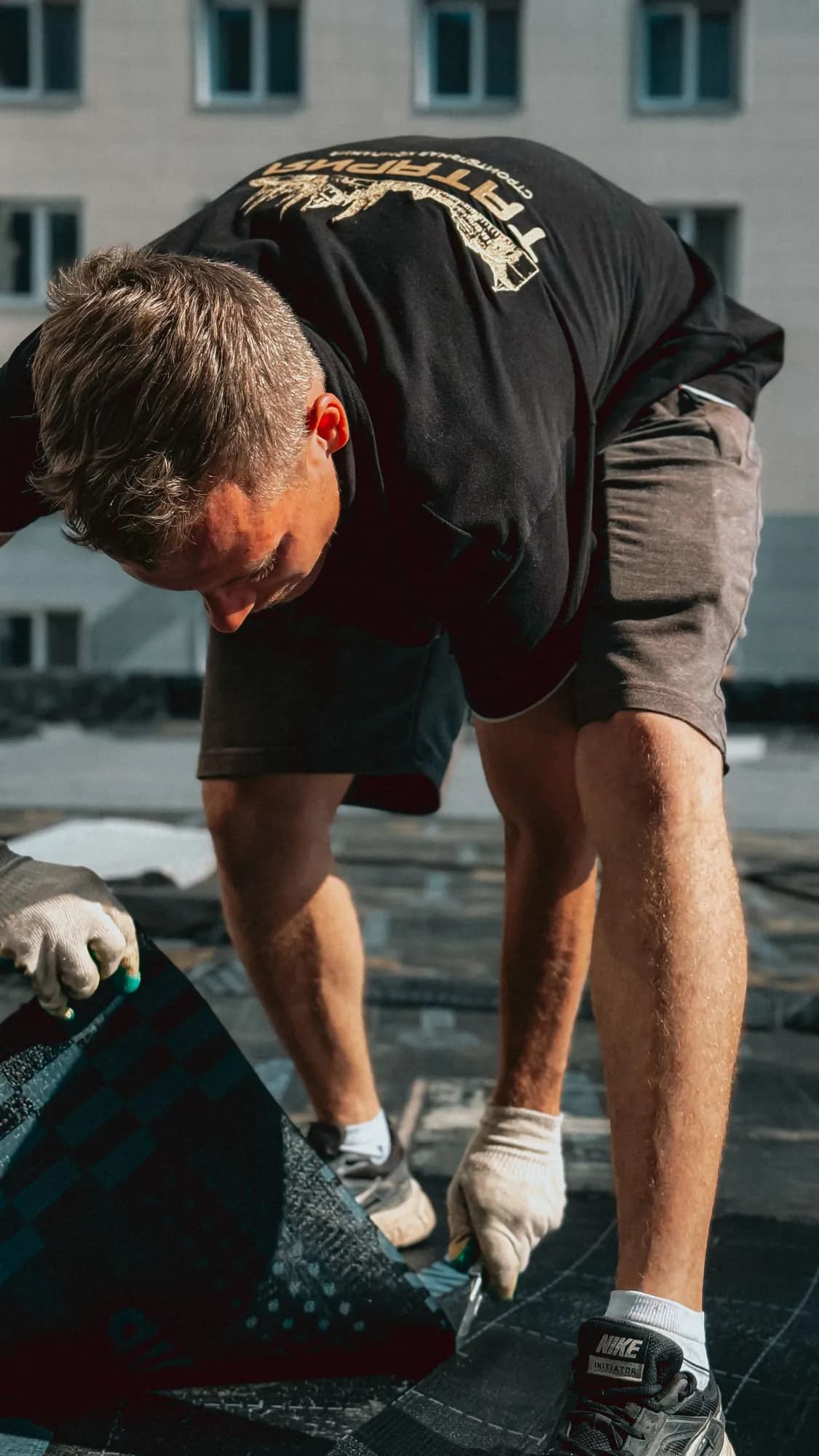 Roofer applying new asphalt shingles