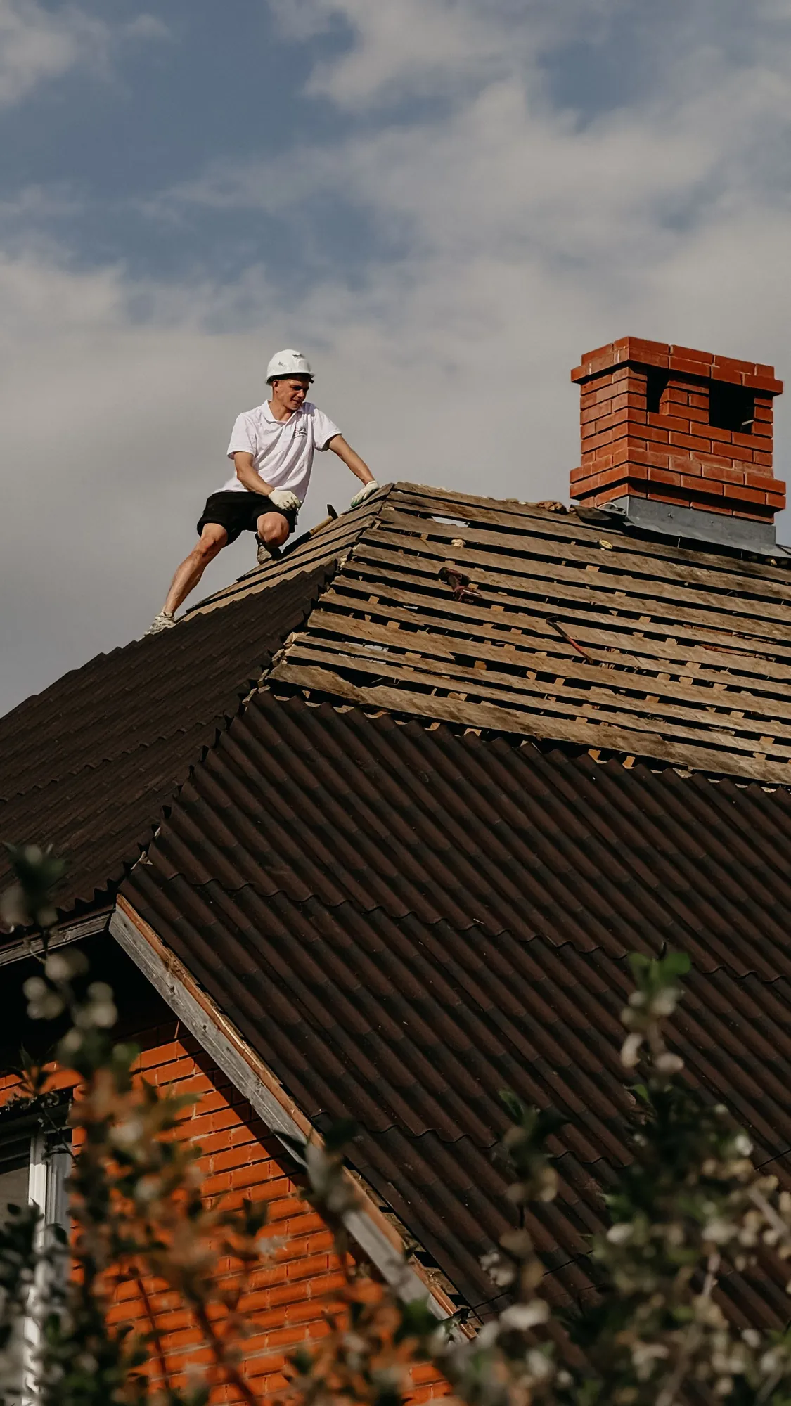 Roofer working on the roof of an older brick home